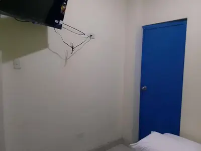 a blue door in a room with a bed at Hospedaje TUTUMEME in Churín