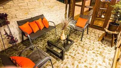 a patio with two chairs and a bench with orange pillows at Casa en Calca in Calca