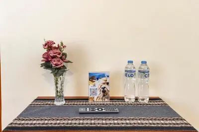 a table with a remote control and two bottles of water at Intiflatscusco Comfortable Stay in the Heart of the City in Cusco