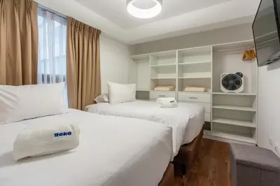 a hotel room with two beds and a tv at Nuvee 2BR by Geko in Lima