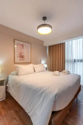 a large white bed in a room with a window at Nuvee 2BR by Geko in Lima