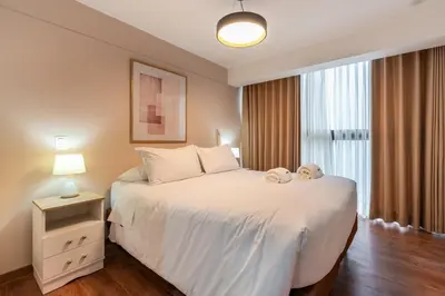 a bedroom with a white bed with a teddy bear on it at Nuvee 2BR by Geko in Lima