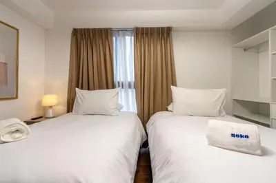 a hotel room with two beds and a window at Nuvee 2BR by Geko in Lima