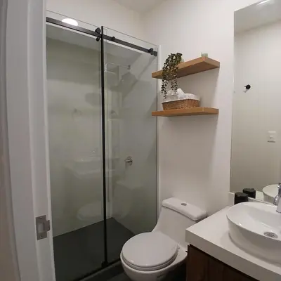 a bathroom with a shower and a toilet and a sink at Vive Barranco, Reserva aquí in Lima