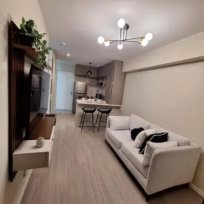 a living room with a couch and a kitchen at Apartamento de ensueño in Lima