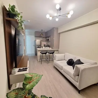 a living room with a white couch and a kitchen at Apartamento de ensueño in Lima