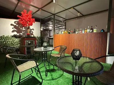 a patio with tables and chairs and a bar at Lima Hostel - Barranco in Lima