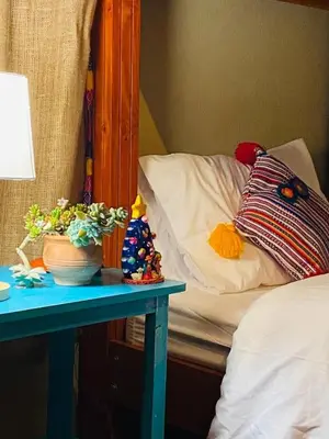a bed with a blue table next to a bed with a bedsenalsenalsenal at Charming Urubamba Cusco house - Kapuliyuq in Urubamba