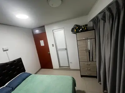 a small bedroom with a bed and a dresser at Huamanga plaza in Ayacucho