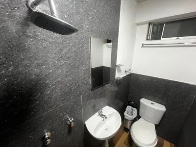 a black and white bathroom with a toilet and a sink at Huamanga plaza in Ayacucho