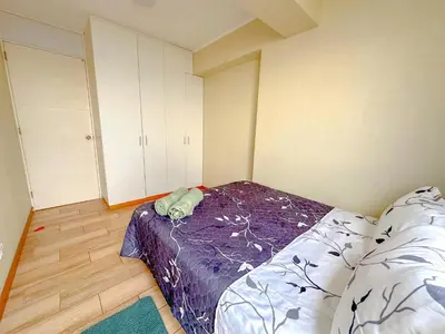 a bedroom with a bed with a purple comforter at Exclusivo con vista al mar - Blue Ocean in Lima