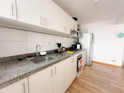 a kitchen with white cabinets and a sink and a refrigerator at Exclusivo con vista al mar - Blue Ocean in Lima