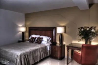a bedroom with a bed and a table and two lamps at Siball Hotel in Abancay
