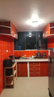 a kitchen with red cabinets and a sink in it at Cusco Hermoso in Cusco