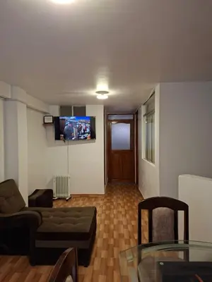a living room with a couch and a tv on the wall at Cusco Hermoso in Cusco