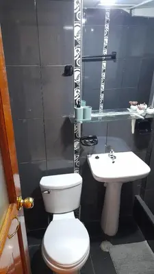 a bathroom with a white toilet and a sink at Cusco Hermoso in Cusco