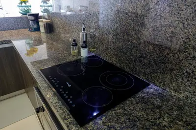 a kitchen counter with a stove with two bottles of wine at BSR Oceanview Family Flat w/ Parking in Lima