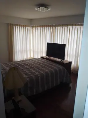 a bedroom with a bed and a window with curtains at Miraflores, Lima, apartamento 2 dormitorios in Lima