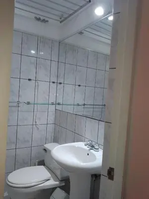 a white bathroom with a toilet and a sink at Miraflores, Lima, apartamento 2 dormitorios in Lima