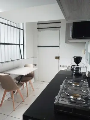 a kitchen with a stove and a table with chairs at Miraflores, Lima, mini apartamento 2 ambientes in Lima