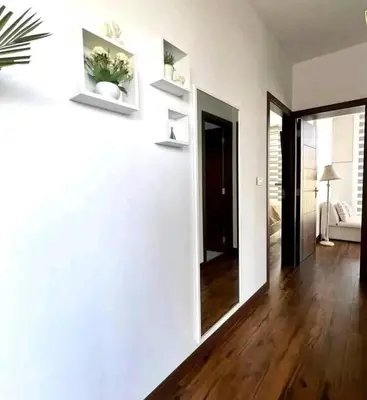 a living room with white walls and wooden floors at La Panaca Del Inka Apartment in Cusco