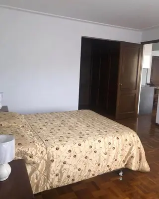 a bedroom with a bed and a wooden floor at Inka Garden Apartment Cusco in Cusco