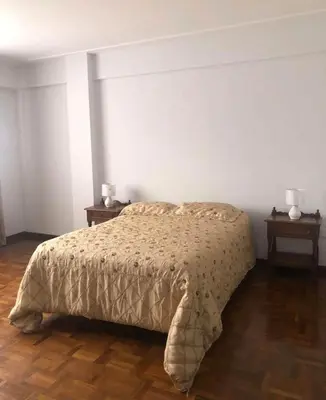 a bedroom with a bed and two night tables at Inka Garden Apartment Cusco in Cusco