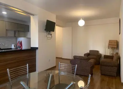 a living room with a couch and a table and chairs at Qori Apartment in Cusco