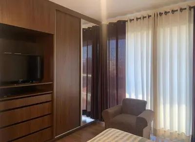 a room with a tv and a chair and a window at Qori Apartment in Cusco