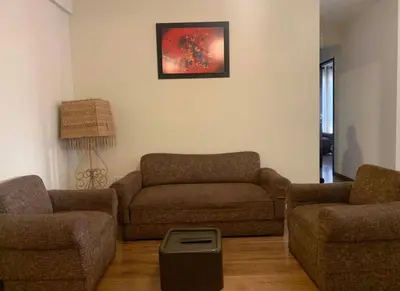 a living room with a couch and two chairs at Qori Apartment in Cusco