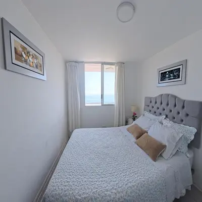 a white bedroom with a bed with a window at Ocean Blue, Vista Frontal Al Mar in Lima