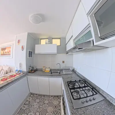 a kitchen with white cabinets and a stove top oven at Ocean Blue, Vista Frontal Al Mar in Lima