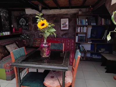 a vase with a sunflower sitting on a table at SOLGARDENs in Cusco