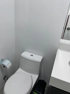 a white bathroom with a toilet and a sink at APARTMENT NEW COMFORTABLE in MIRAFLORES in Lima