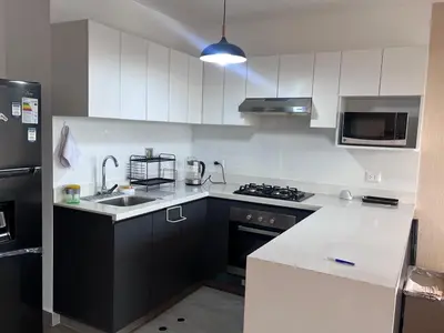 a kitchen with white cabinets and a black refrigerator at APARTMENT NEW COMFORTABLE in MIRAFLORES in Lima