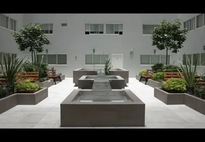 a courtyard with tables and benches in a building at Apartamento familiar 3 habitaciones, piscina cerca a Miraflores in Lima
