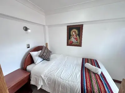 a bedroom with a bed and a picture on the wall at Libertrek in Cusco