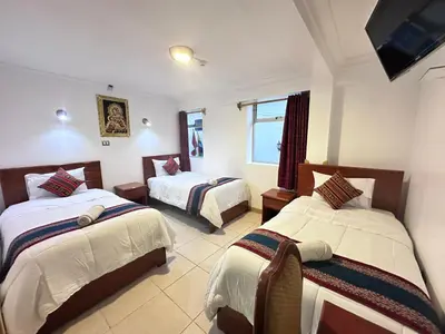 a hotel room with two beds and a flat screen tv at Libertrek in Cusco
