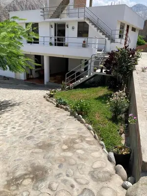 a large white house with a walkway in front of it at Viña J Felix in Lunahuaná