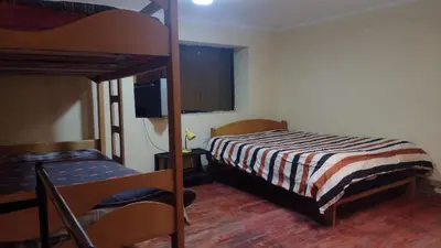 a bedroom with two bunk beds and a television at Roman House 701 in Cusco