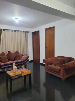 a living room with two couches and a coffee table at Departamento cerca del aeropuerto in Lima