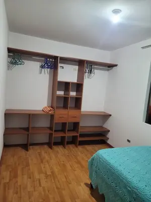 a bedroom with a bed and a book shelf at Departamento cerca del aeropuerto in Lima