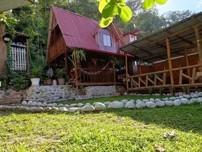 a house with a red roof and a yard at Montañita Lodge in La Merced