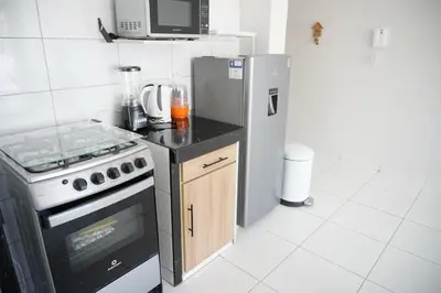a kitchen with a stove and a refrigerator at Jatun Coya in Huancayo