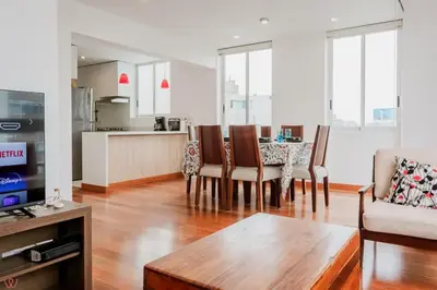 a living room with a table and chairs and a kitchen at Charming 3BR in Barranco in Lima
