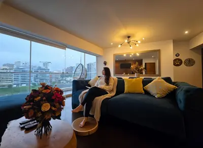 a woman sitting on a couch in a living room at E LarcomarZone Sea View All Inclusive 3B 701 in Lima