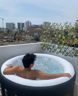 a man in a bath tub on a balcony at House in Barranco, Hot Tub & Rooftop Cinema, 11 P in Lima