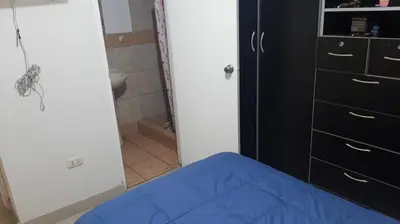 a bedroom with a blue bed and a closet at Departamento 3 cuartos frente al mar en San Miguel, Peru in Lima