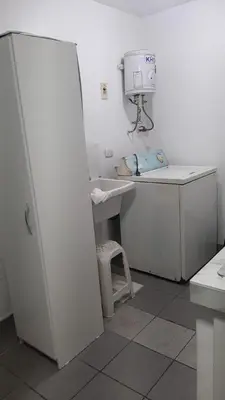 a white kitchen with a sink and a white refrigerator at Departamento 3 cuartos frente al mar en San Miguel, Peru in Lima