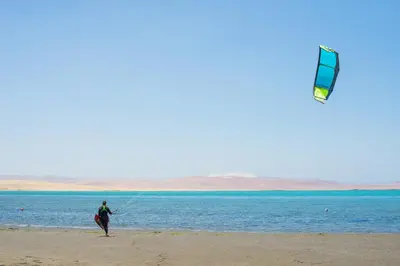 a person is flying a kite on the beach at Bamboo Paracas Hotel in Paracas